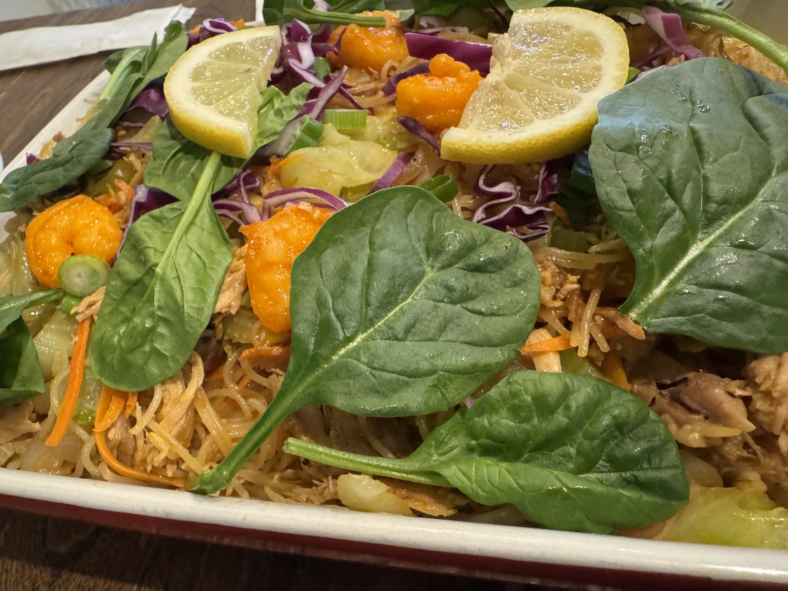 A platter of Pancit Bihon, stir-fried rice noodles with chicken, shrimp, and vegetables